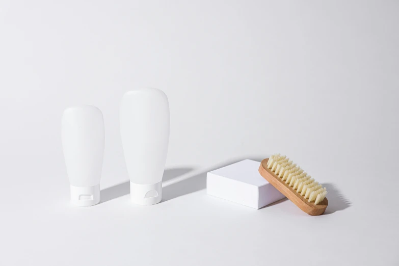 a single tooth brush is sitting next to three small tubes