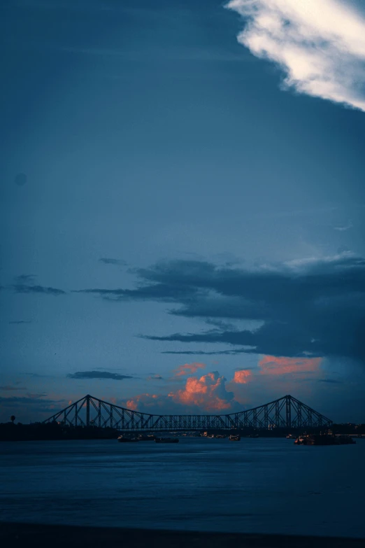 a very long bridge with some pretty clouds above it