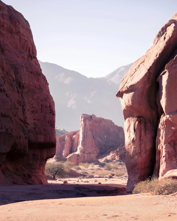 a desert setting with a cliff and some rocks in the foreground