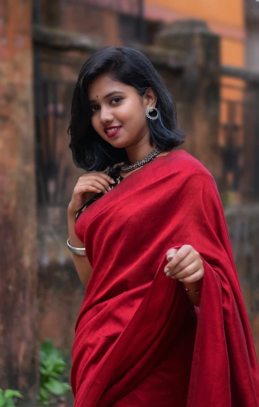 a woman in a red dress holding onto a red scarf