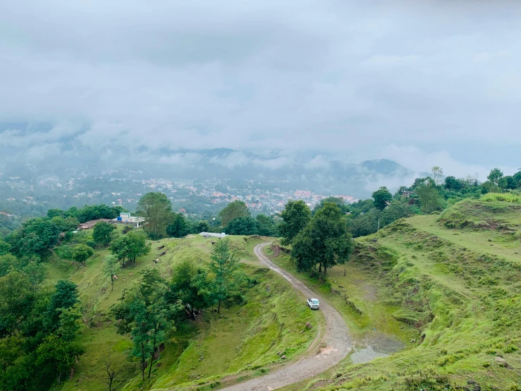 a small car is parked on the side of a green hill