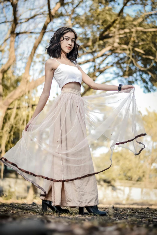 a woman in a white dress standing in a forest