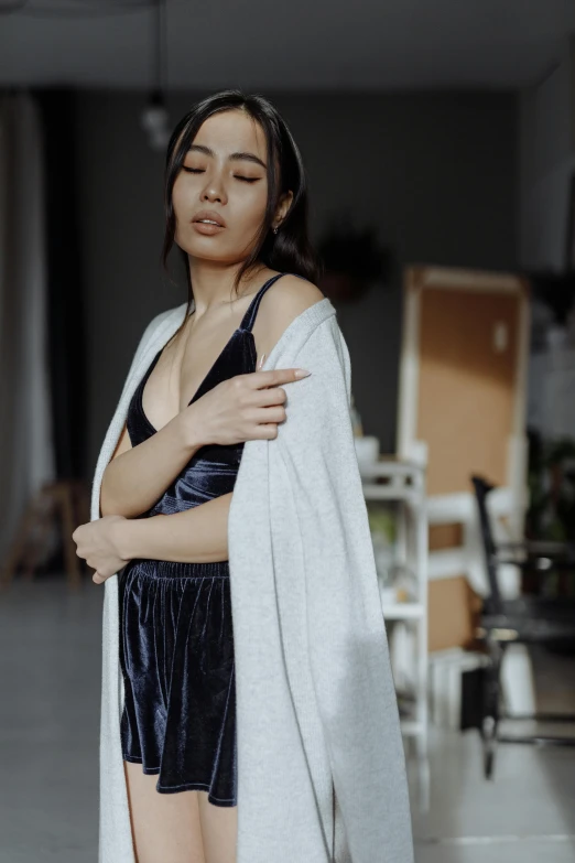 a woman with her arms crossed in an open white robe