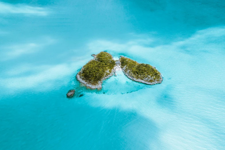 an island in the middle of some clear blue water