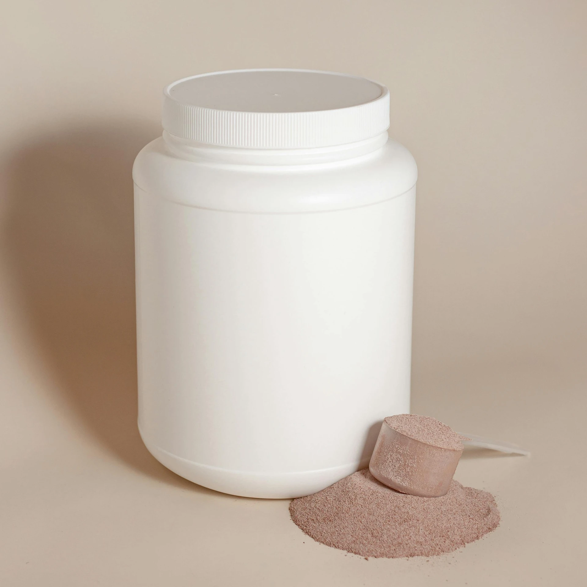 a white container next to a brown substance on a white surface