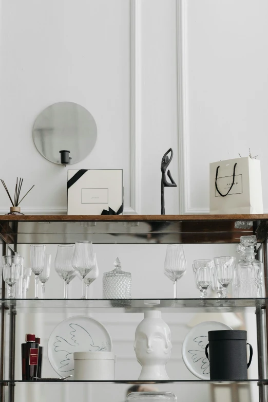 a table topped with lots of glassware on top of a shelf