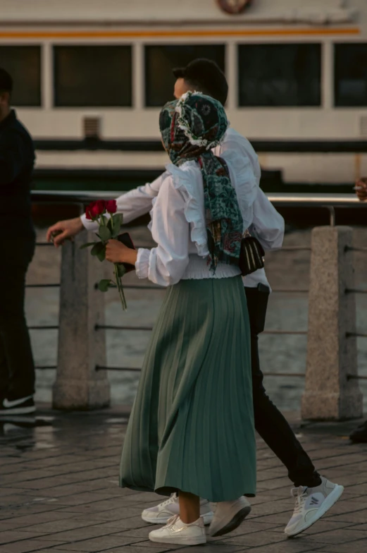 a woman in a skirt carries her hand out for an emce