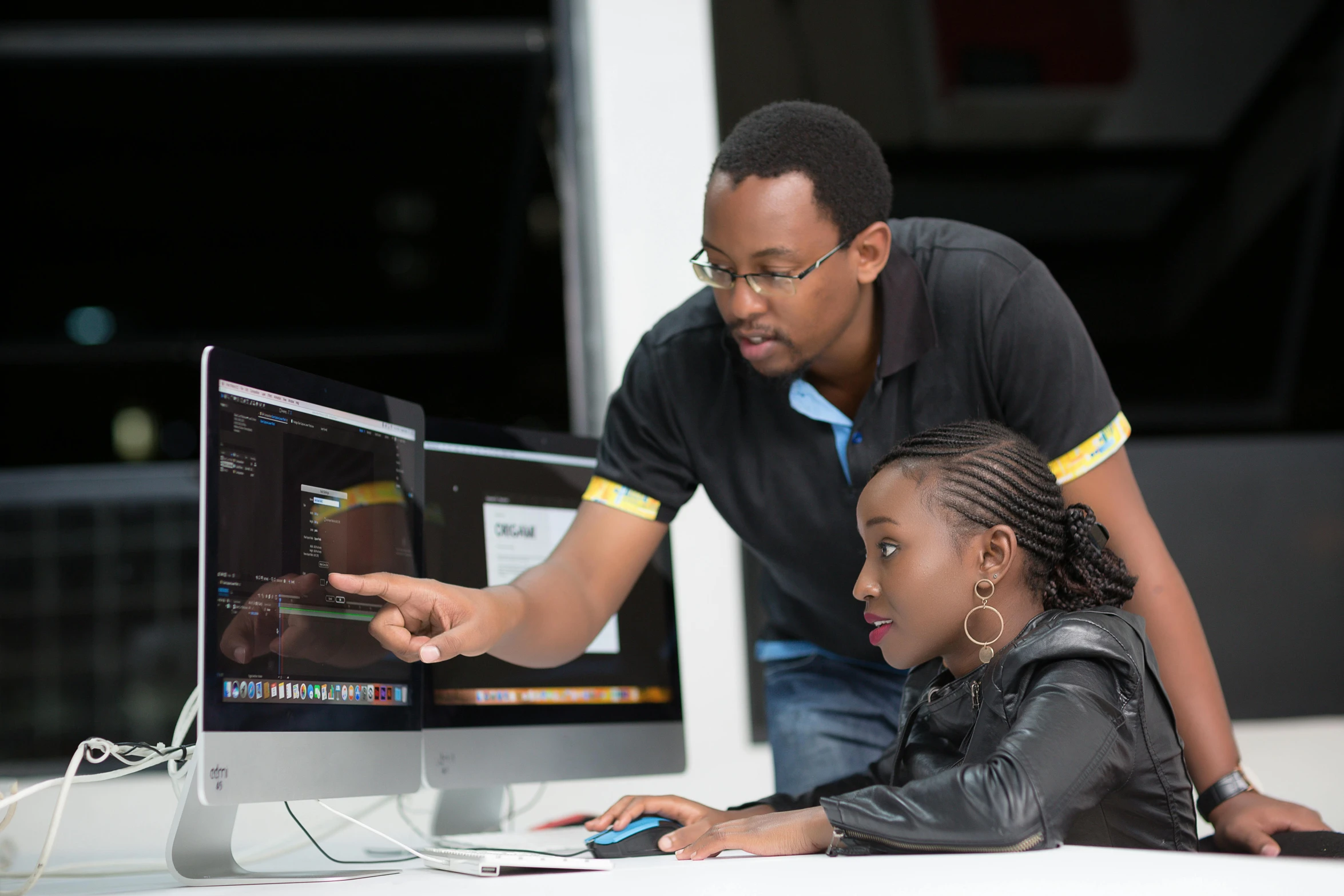 a man showing another woman soing on a computer