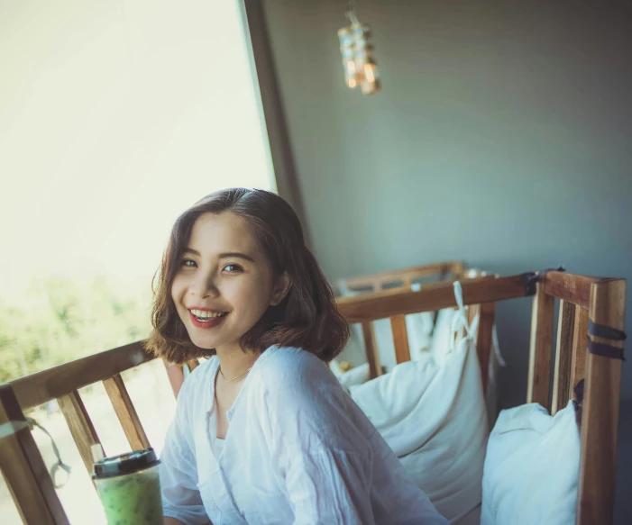 the girl is smiling while she holds her coffee