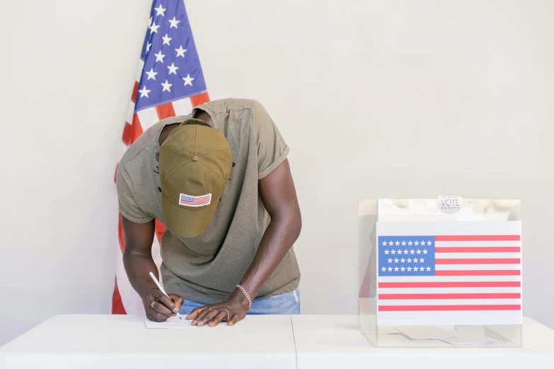 a man kneeling down at a table with an american flag