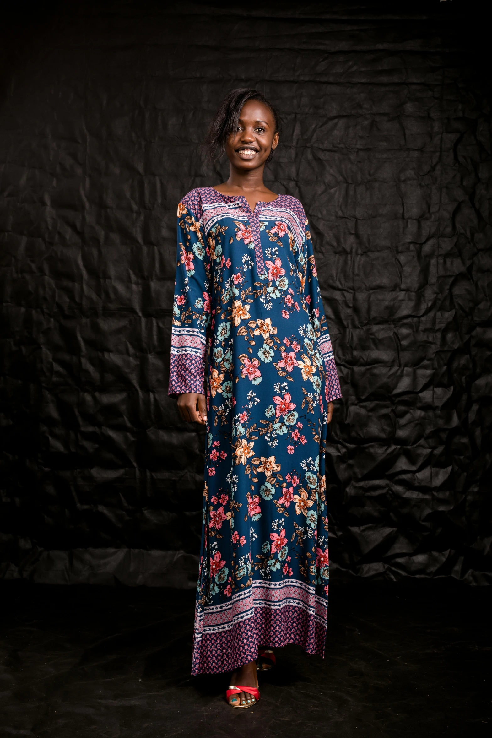 an african woman standing in front of a black background