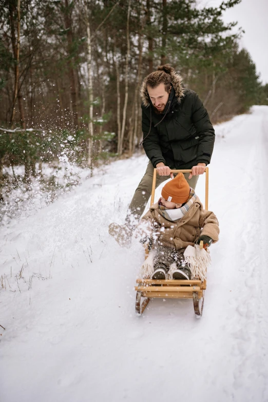 an image of a person pulling a child in the sled