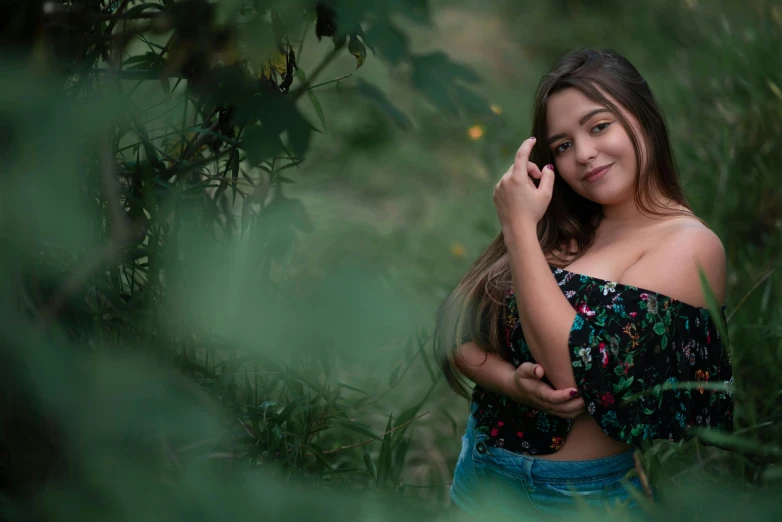 a  standing in a field with her hand on her ear