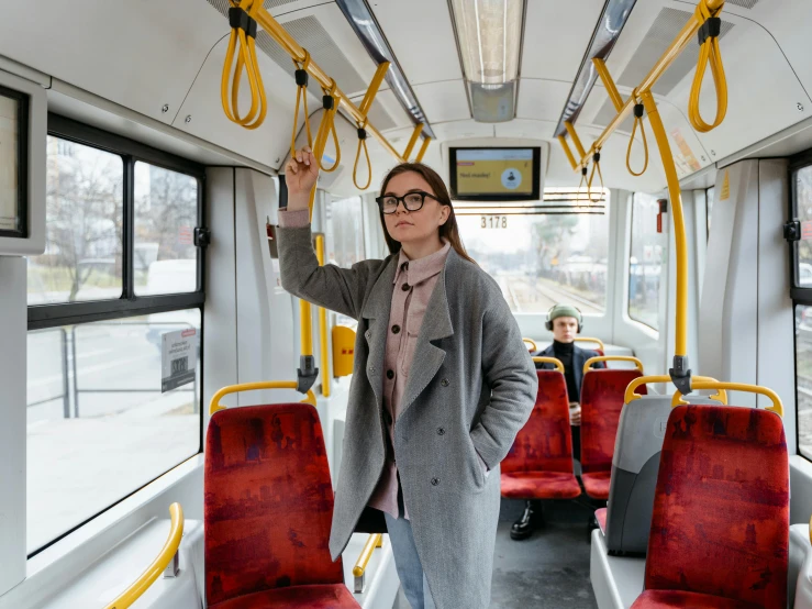 woman with glasses holding up a cell phone in a commuter train