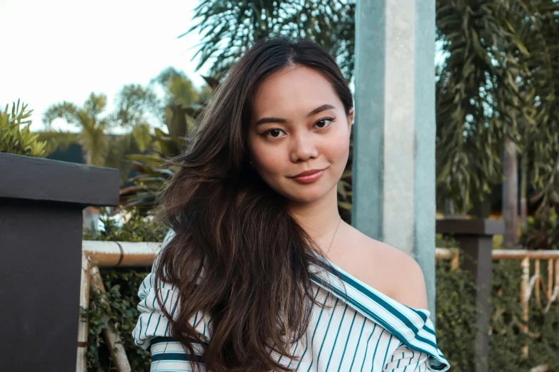 a woman wearing a blue striped shirt and smiling