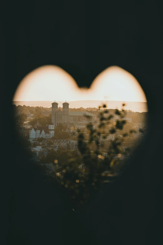 a view of some buildings is taken from inside a heart shaped window