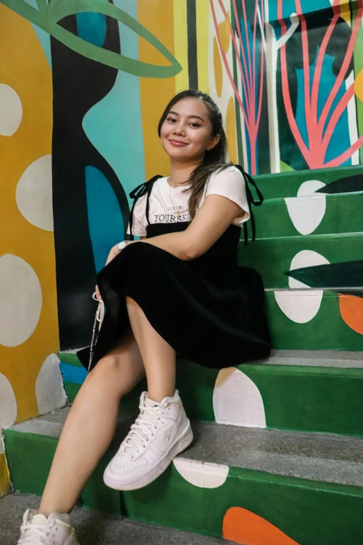 the girl is sitting on the stair case posing for the camera