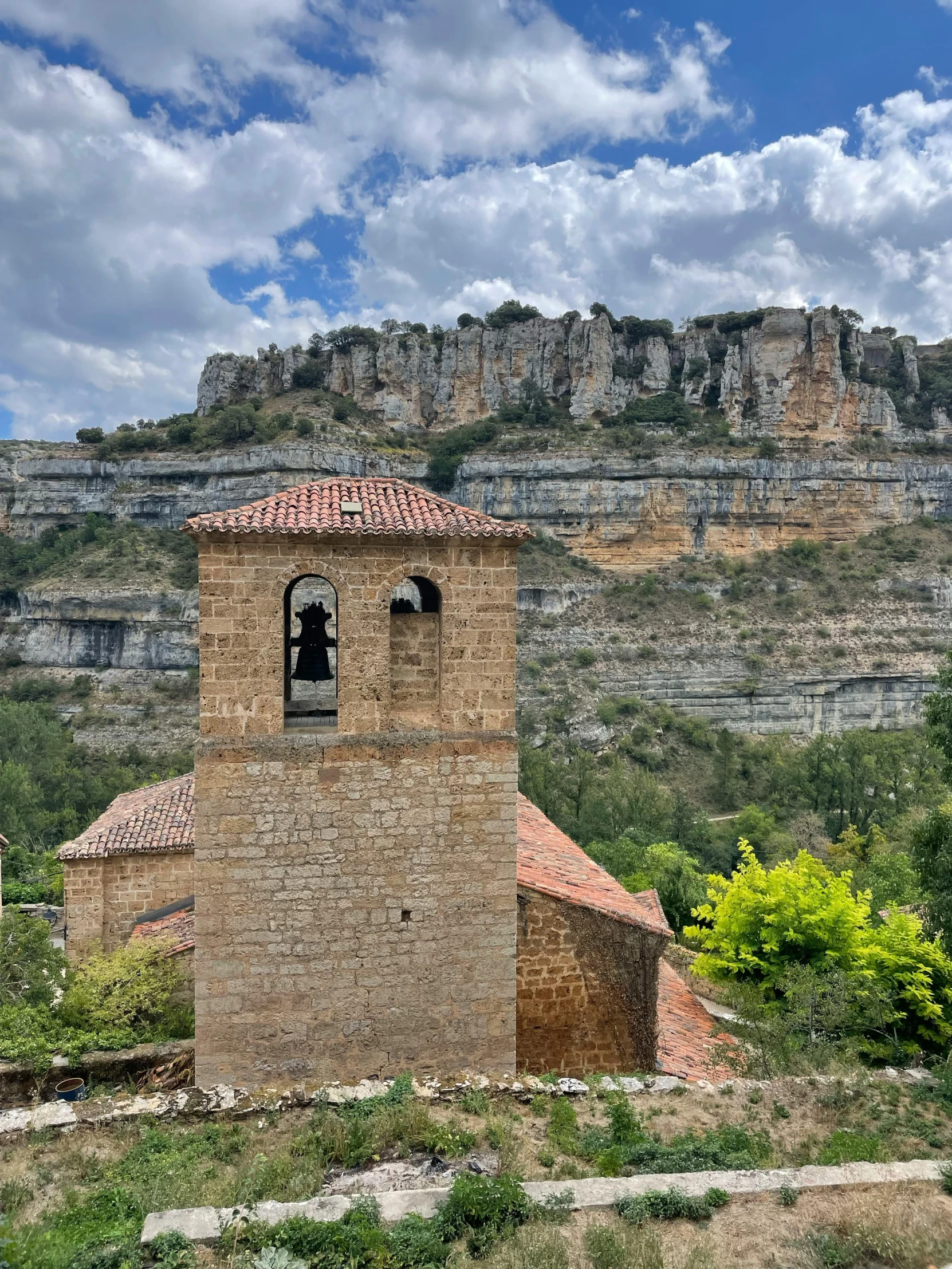 a stone building surrounded by lush green trees