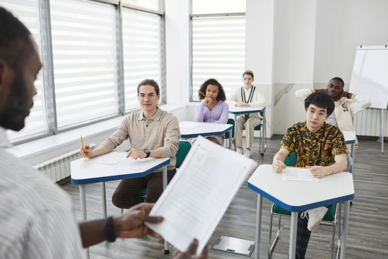 a group of people are sitting at desks