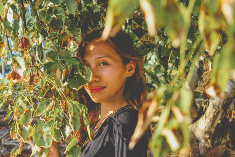 a young woman smiling in between plants