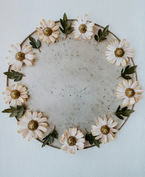 the floral wreath is placed in a round frame