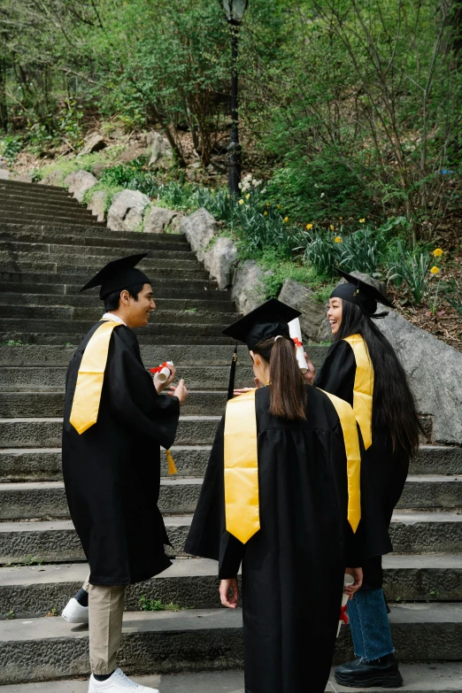 graduates and students walking up some stairs