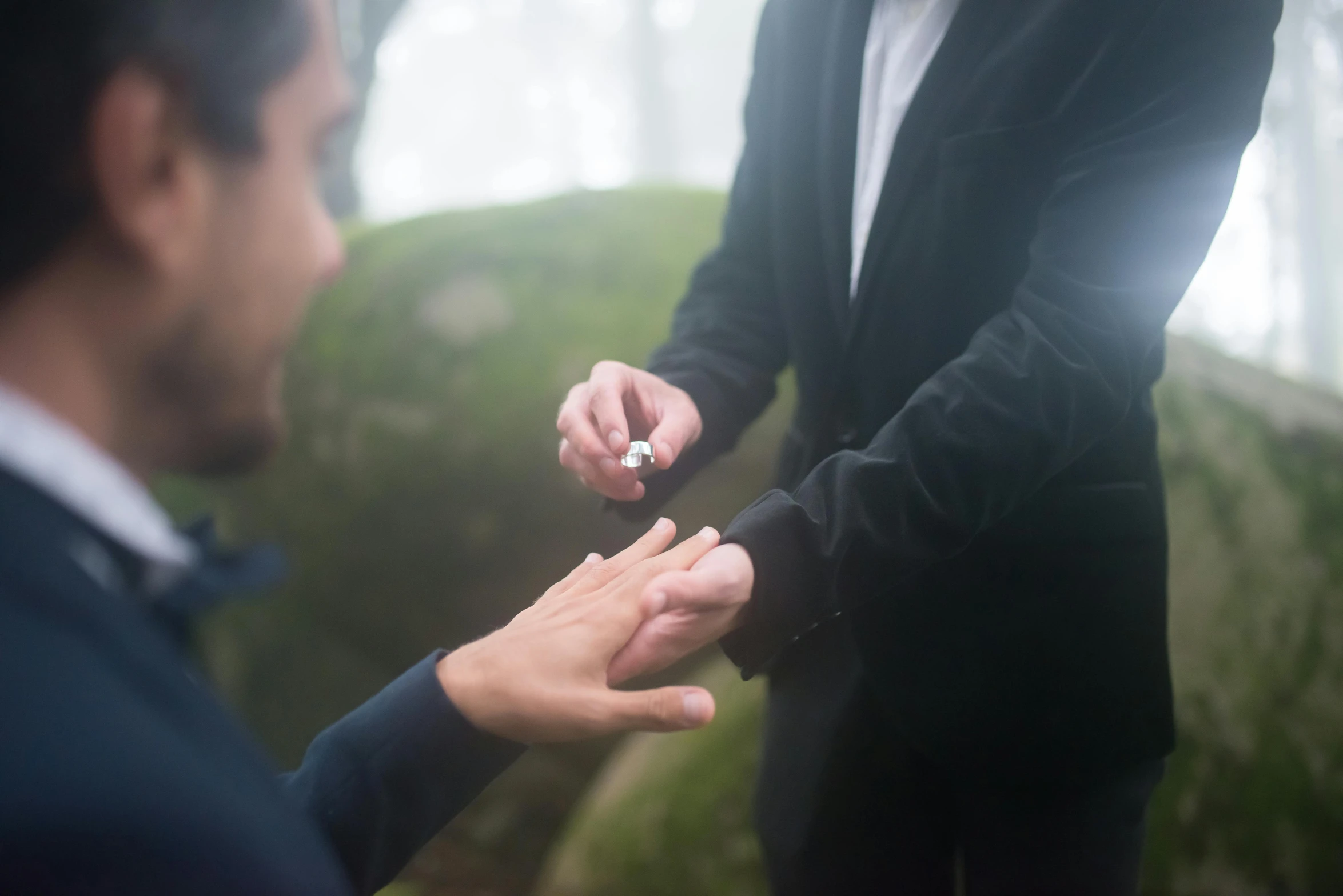 a person in a suit holding soing while another man holds out his hand