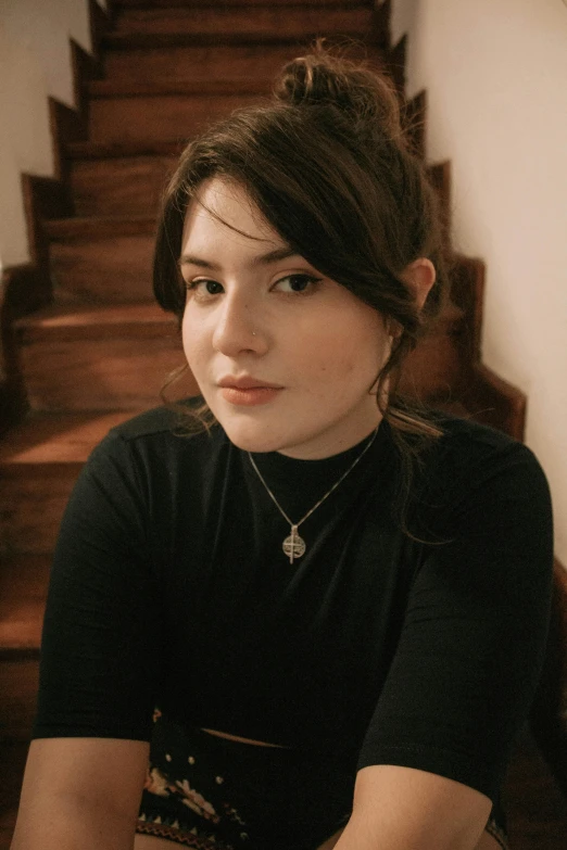 a woman posing for a picture while sitting on a set of steps