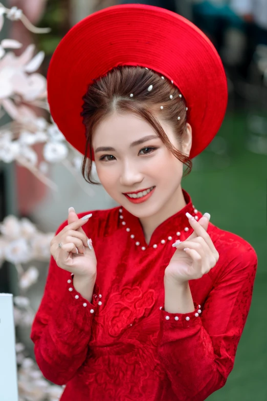 an asian woman dressed in a bright red dress and red hat