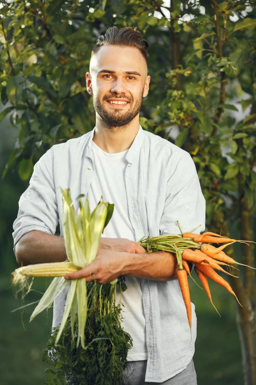the smiling man has two carrots ready to be picked