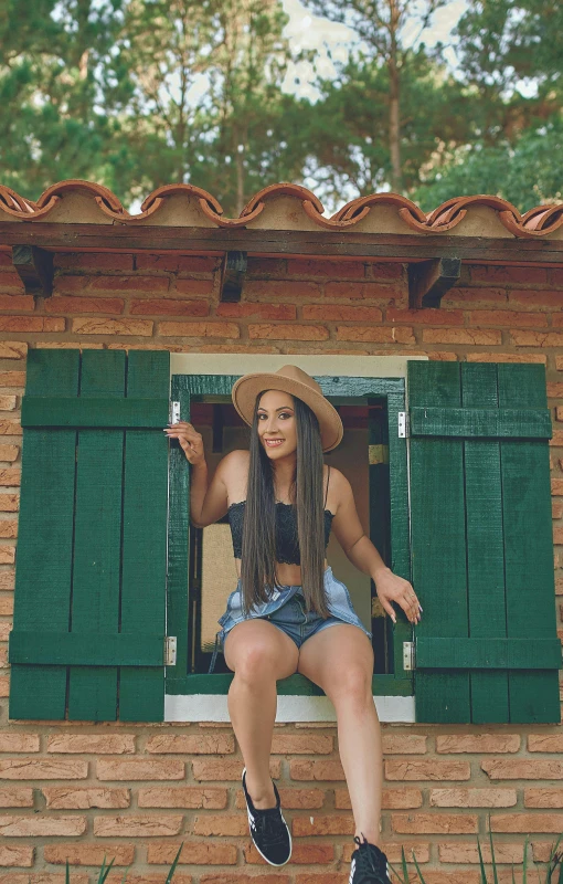 woman wearing denim skirt sitting on window ledge