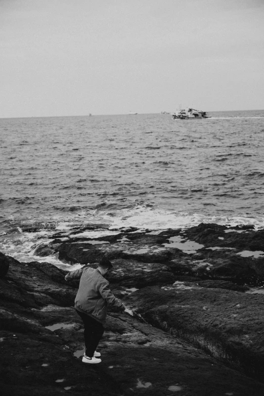 an old person standing on the shore of some water