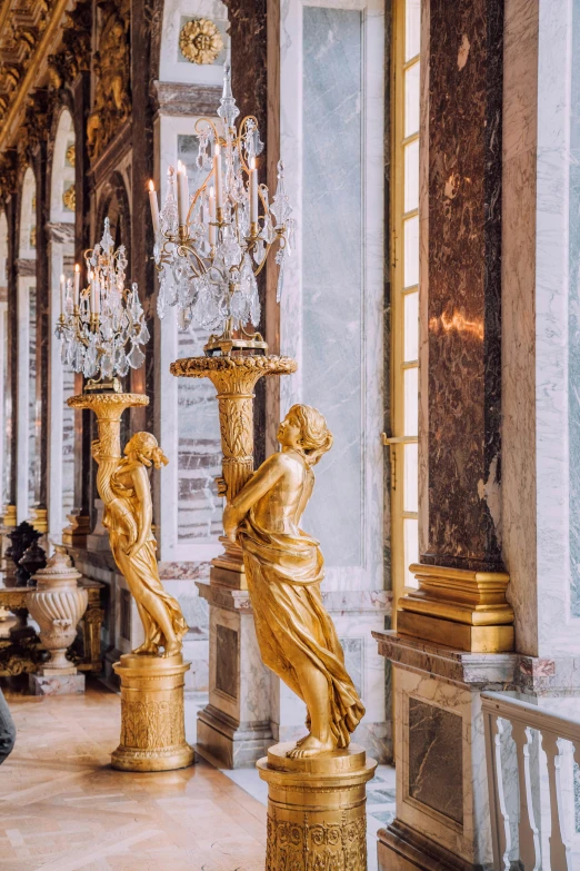 two gold statues sit in the middle of a room