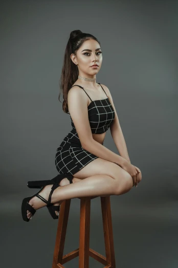 woman in black and white dress sitting on stool