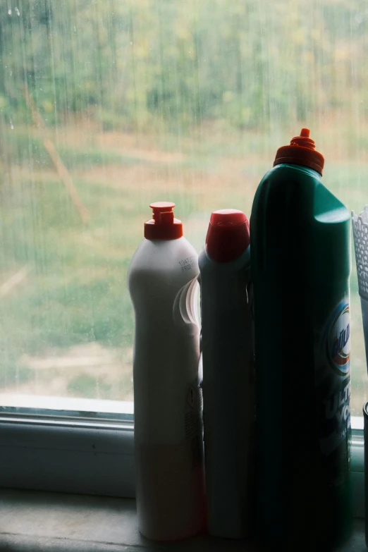 a bunch of bottles are sitting on the windowsill