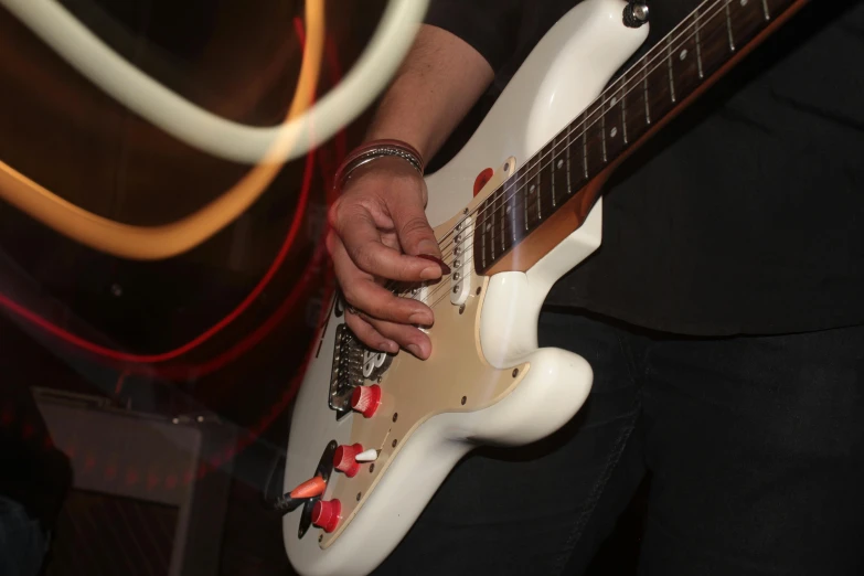 a man is holding a white guitar in his hand