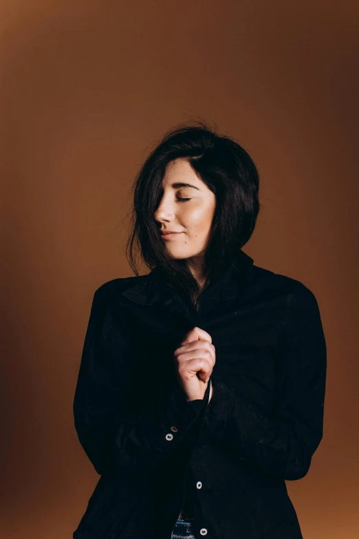 a woman standing in front of a brown background