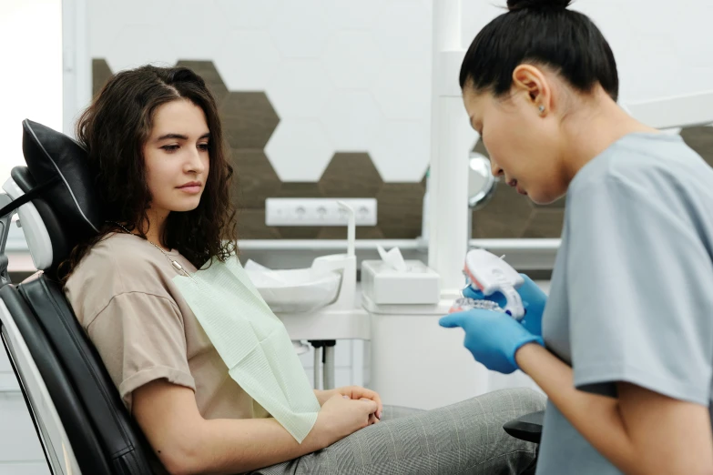 a girl getting her teeth brushed with a dentist