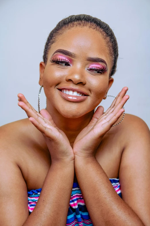 a woman with pink eye makeup and a big smile