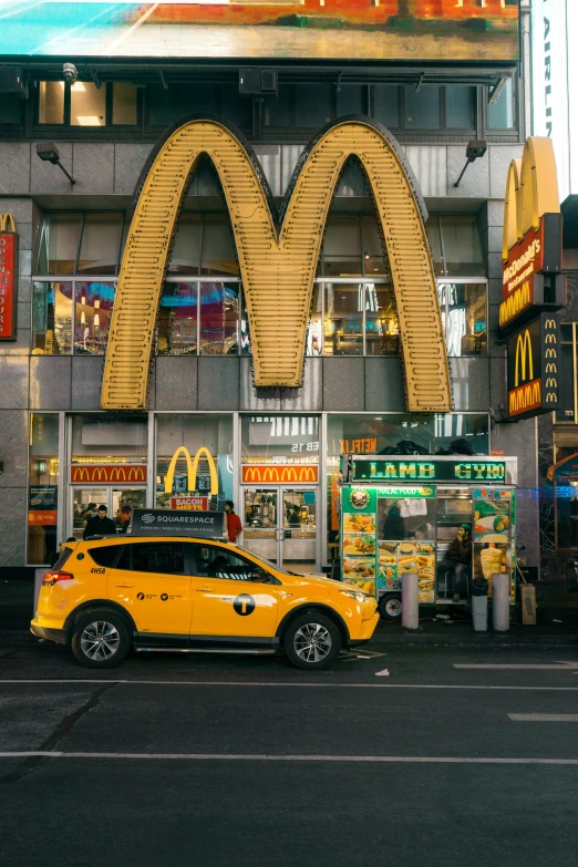 a fast food restaurant with a neon yellow suv at its entrance