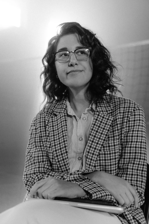 a woman wearing glasses sitting at a desk