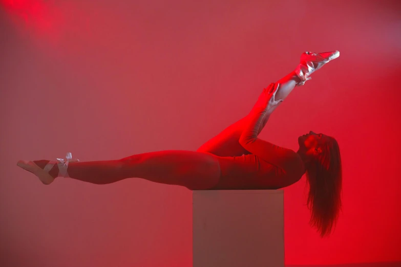 the woman is performing on the red lighting stage