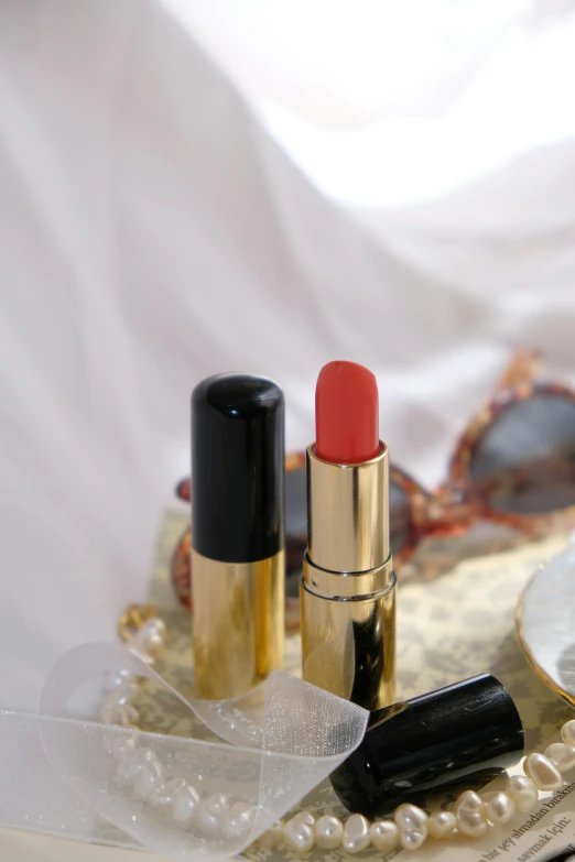 three lipsticks, pearls and an envelope