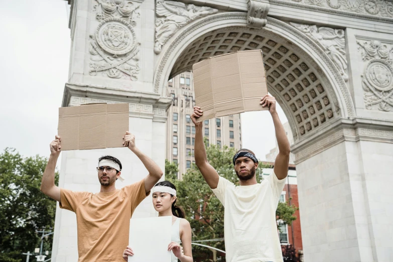 a man holds two cardboard boxes over his head and another man holds a box up above his head