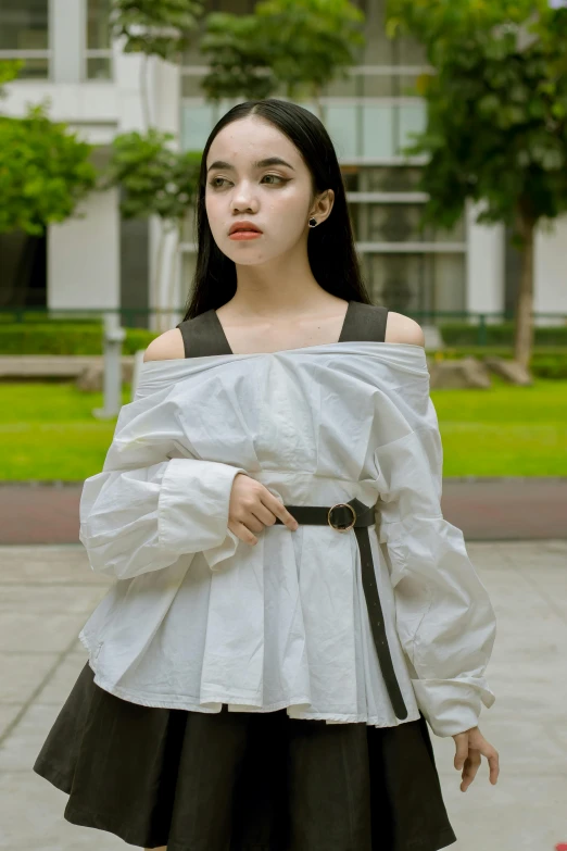 a young lady in white and black is posing for the camera