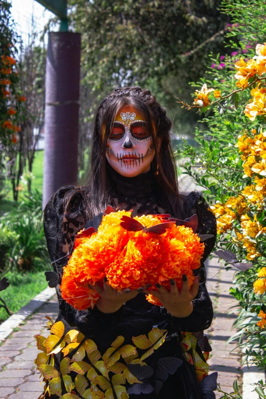 a woman dressed as a skeleton holding flowers