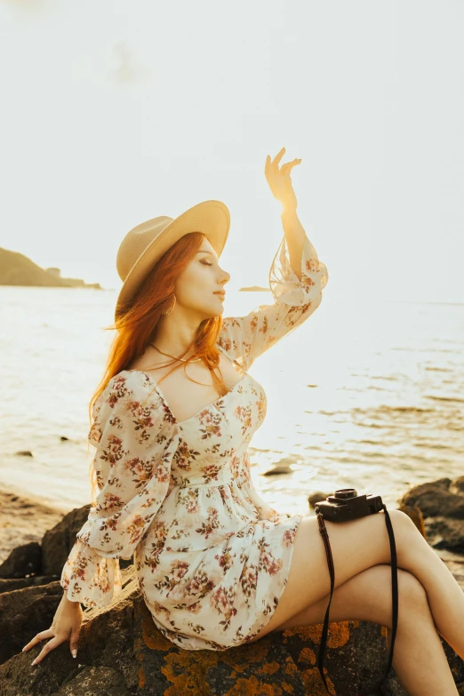 a woman is sitting on a rock and waving