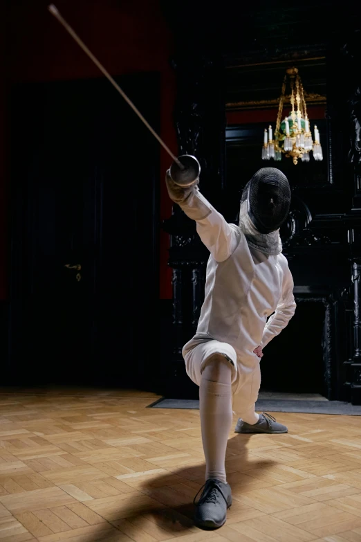 a  in white clothes holding a stick in front of a piano