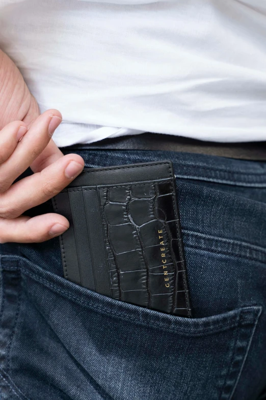 a person in a white shirt has his left arm on the pocket of their black crocgrat wallet