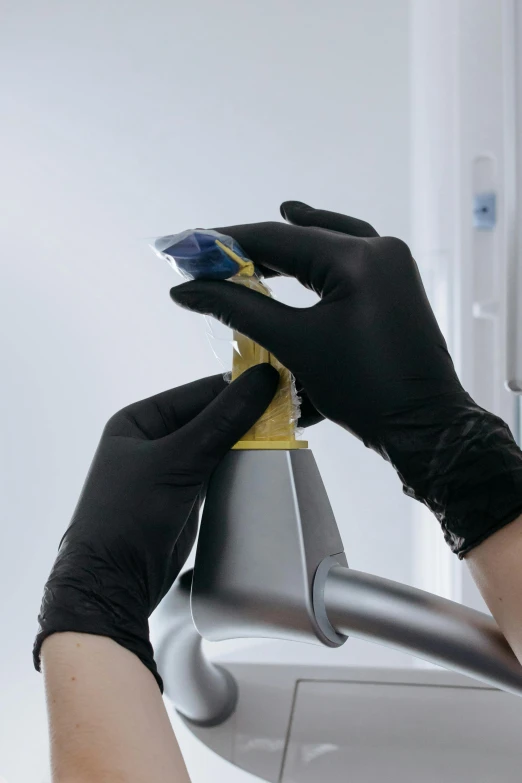 a person in black gloves cleaning a car mirror